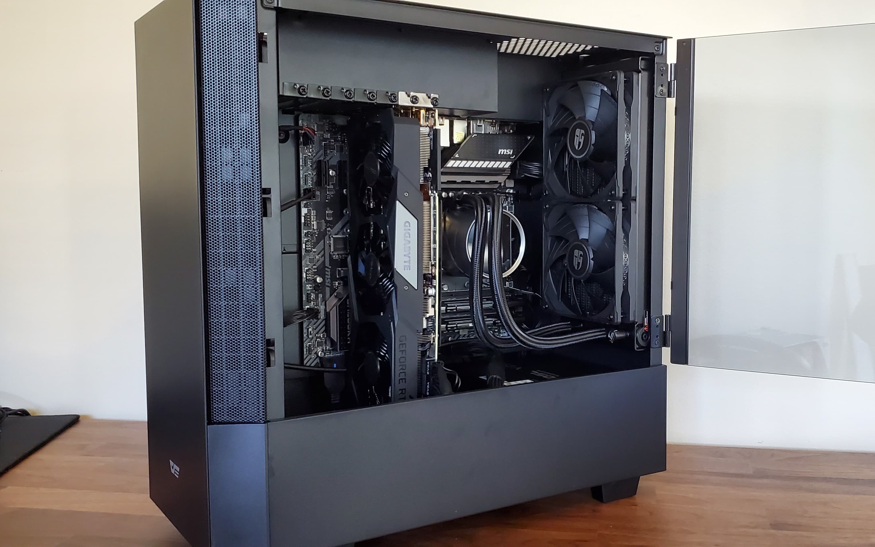 My first PC build in a darkFlash V22 case with the glass door open and a vertical graphics card